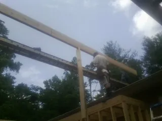 Carpenter setting a ridge beam over a new addition frame — Ice Dam Removal by Roofing Brothers in Stroh