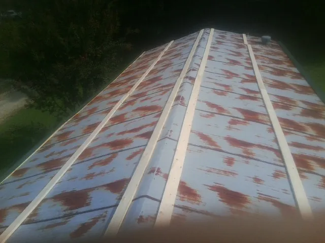 Rusted metal roof panels with new wood purlins before replacement — Storm Damage Roof Repair in Stroh by Roofing Brothers