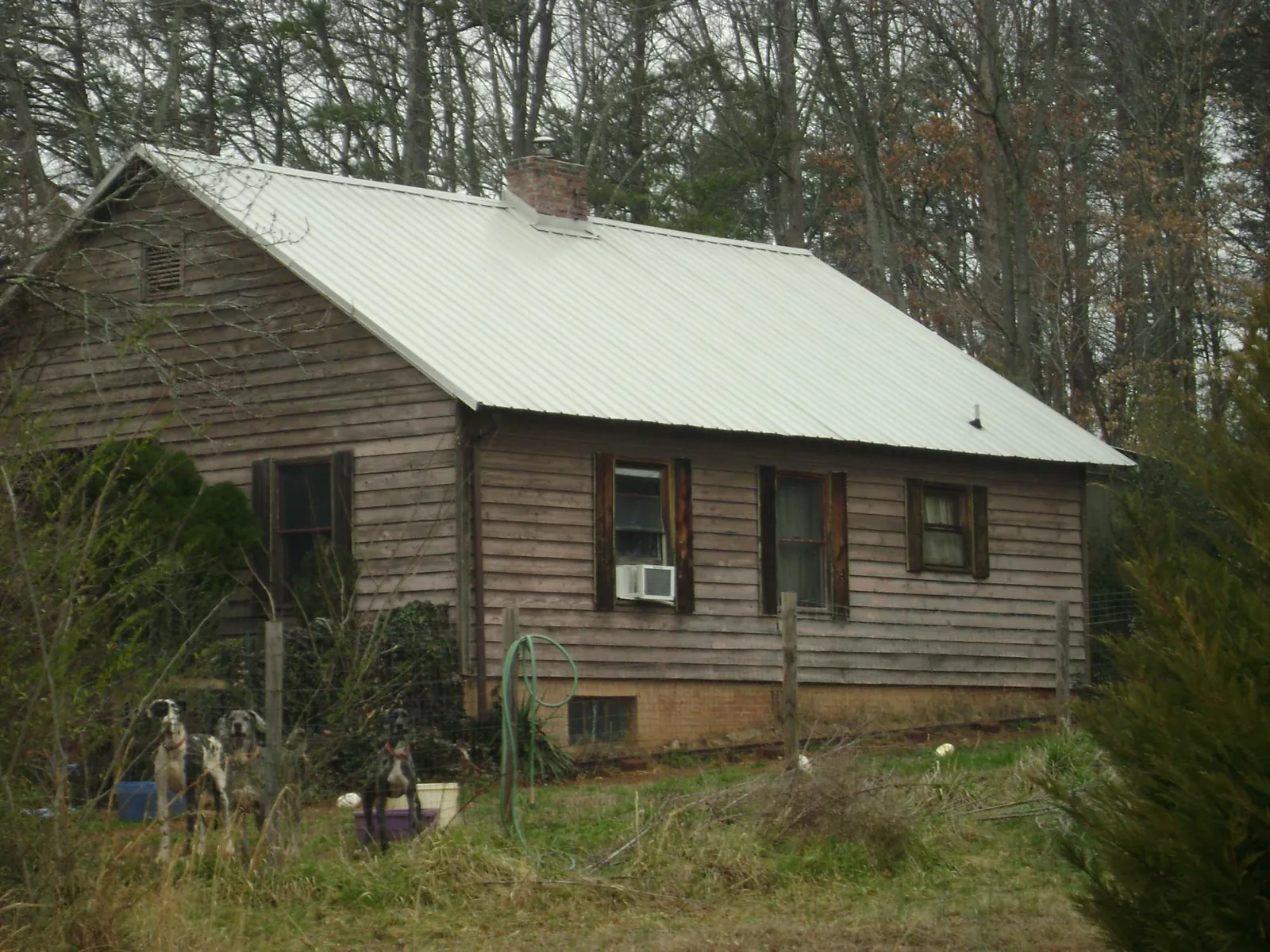 White metal roof on an old wood sided farmhouse, from a Metal Roof Installation job in Stroh